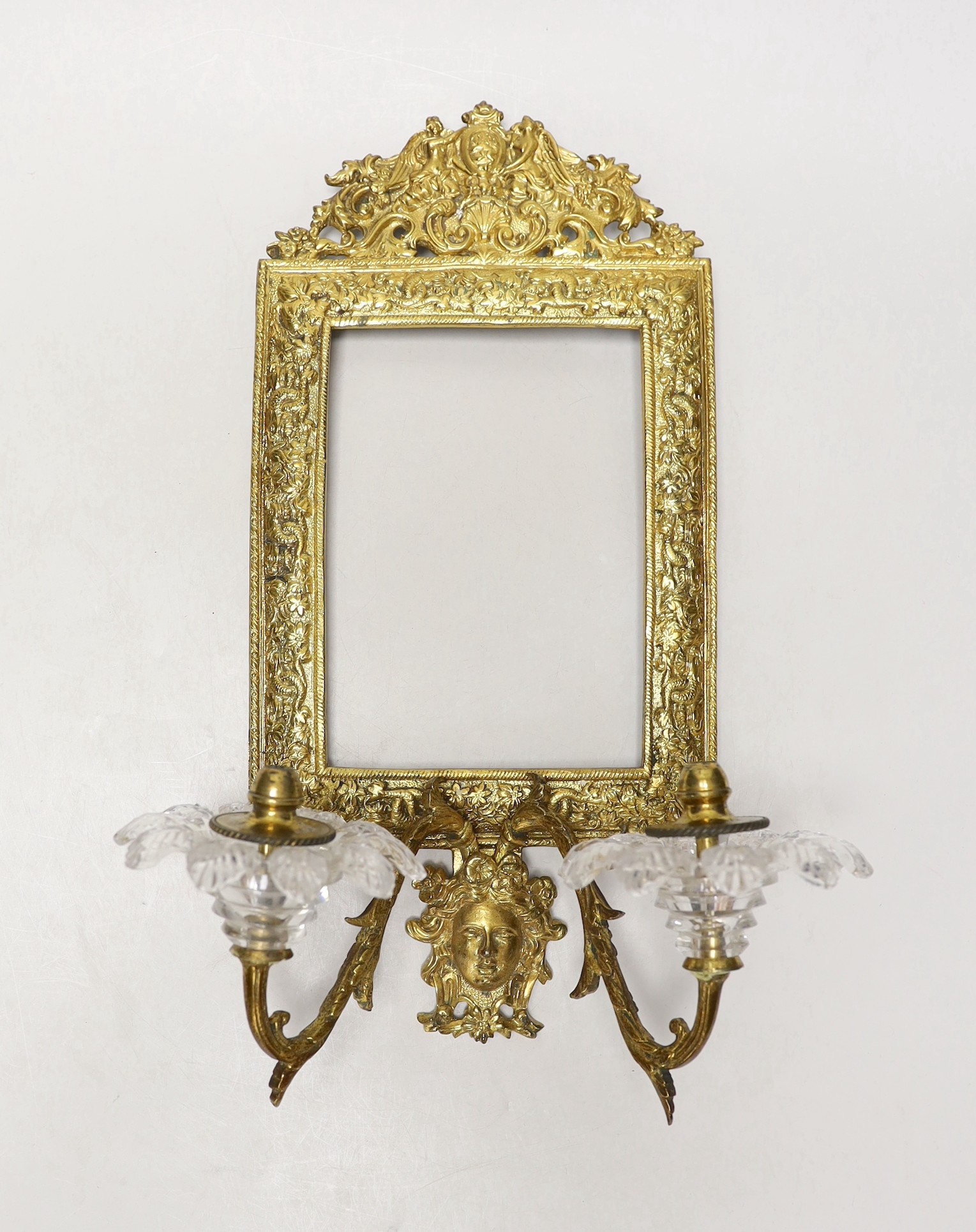 A decorative two branch ormolu wall mirror, lacking the mirror inset. 39cm tall overall, 16.5 x 11.5cm